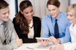 Business Team Of Four Enjoying Work Stock Photo