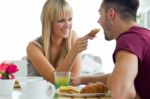 Happy Young Couple Enjoying Breakfast In The Kitchen Stock Photo