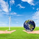 Hand Holding Wind Turbine And Earth Stock Photo