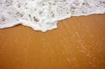 Sea Wave With Foam On Sand Stock Photo