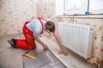 Young Handyman Installing Wooden Floor Stock Photo