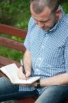 Man Writing In Notepad Stock Photo