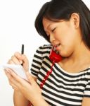 Woman On Phone Taking Notes Stock Photo