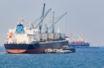 Container Boat Loading Goods Over Clear Blue Water Sea Use For Vessel ,nautical Transportation And Ocean Logistic Industry Stock Photo