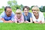 Happy Family Lying On Lush Green Grassland Stock Photo