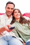 Happy Young Couple Watching Tv On Sofa Stock Photo