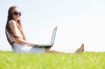 Young Feamle Sit In The Park And Using A Laptop Stock Photo