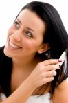 Portrait Of Woman Combing Her Hair On White Background Stock Photo