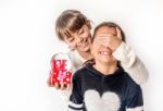 Little Girl Giving Surprise Love Gift To Her Friend With White Background Stock Photo