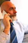 Middle-aged Businessman Listening On Smartphone At Home Stock Photo