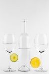 Isolated Bottle And Glasses With Lemon And Lime Stock Photo