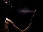 Woman's Perfume In The Hand On Black Background Stock Photo