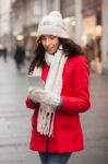 Woman In Red Coat And Wool Cap And Gloves With Smartphone In Han Stock Photo