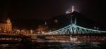 Liberty Bridge And Statue Illuminated At Night In Budapest Stock Photo