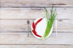 Red Hot Chilli Pepper And Scallions On Plate Stock Photo