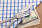 Fork And Knife On Dollar Bills Stock Photo