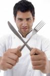 Chef Holding Crossed Fork And Knife Stock Photo