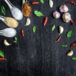 Top View Of Food Ingredients And Condiment On The Table, Ingredients And Seasoning On Dark Wooden Floor Stock Photo