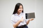 Portrait Of Thai High School Student Uniform Beautiful Girl Using Her Tablet Stock Photo