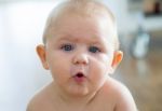 Cute Smiling Baby Sitting At Home Stock Photo