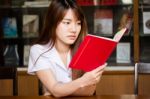 Portrait Of Thai Adult Student University Uniform Beautiful Girl Reading Red Book Stock Photo