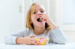 Beautiful Child Eating Sweets At Home Stock Photo