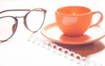 Close Up Of Coffee Cup With Book And Eyeglasses Stock Photo