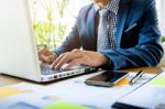 Business Man Working At Office With Laptop, Tablet And Graph Dat Stock Photo