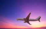 Commercial Airplane Flying At Sunset Stock Photo