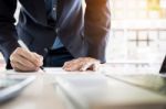 Businessman Writing In A Document. Focus On The Tip Of The Pen Stock Photo