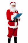 Santa Claus Making List Of Gift Recipients Stock Photo