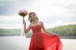 Beautiful Woman Wear Red Evening Dress Hold A Bouquet Of Flowers Stock Photo