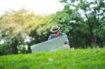 A Happy Traveller Mid Aged Man Sit Outdoor In Green Park, Lookin Stock Photo