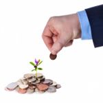 Hand Puts A Penny To A Heap Of British Coins Stock Photo