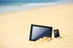 Tablet And Smartphone On The Beach Stock Photo