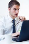 Young Handsome Man Working In His Office With Laptop Stock Photo