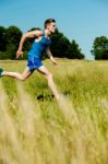 Young Man Running Through Meadows Stock Photo