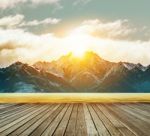 Wood Terrace And Fresh Water Lake With Sun Rising Behind Snowcaped Mountain Stock Photo