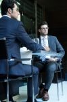 Two Smiling Business Men Have Dinner At Restaurant Stock Photo