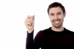 Smiling Young Man Showing Key Stock Photo