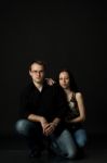 Handsome Young Couple Posing Sitting In Studio Stock Photo