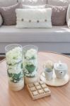 Glass Vase Of Plants And Tea Cup Set On Wooden Round Table Stock Photo