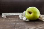 An Apple Surrounded By A Measuring Tape Tailor On Wood Stock Photo