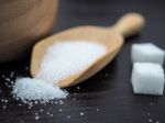 Wooden Bowl And Spoon With Sugar Cube On Dark Wood Background Stock Photo