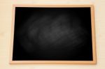 Blank Black Chalkboard With Wooden Frame On Wood Background Stock Photo