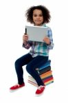 Adorable Kid With Tablet Pc Sitting On Books Stock Photo