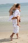 Couple Piggyback Ride At Beach Stock Photo