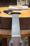 Yellow Acoustic Guitar On Wooden Table Stock Photo