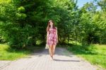 Beautiful Brunette Standing Barefoot On The Sidewalk Stock Photo