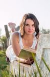 Girl Reading Book Outdoors Stock Photo